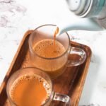 Comparing a cup of traditional Karak tea with a glass of organic green tea Dubai UAE